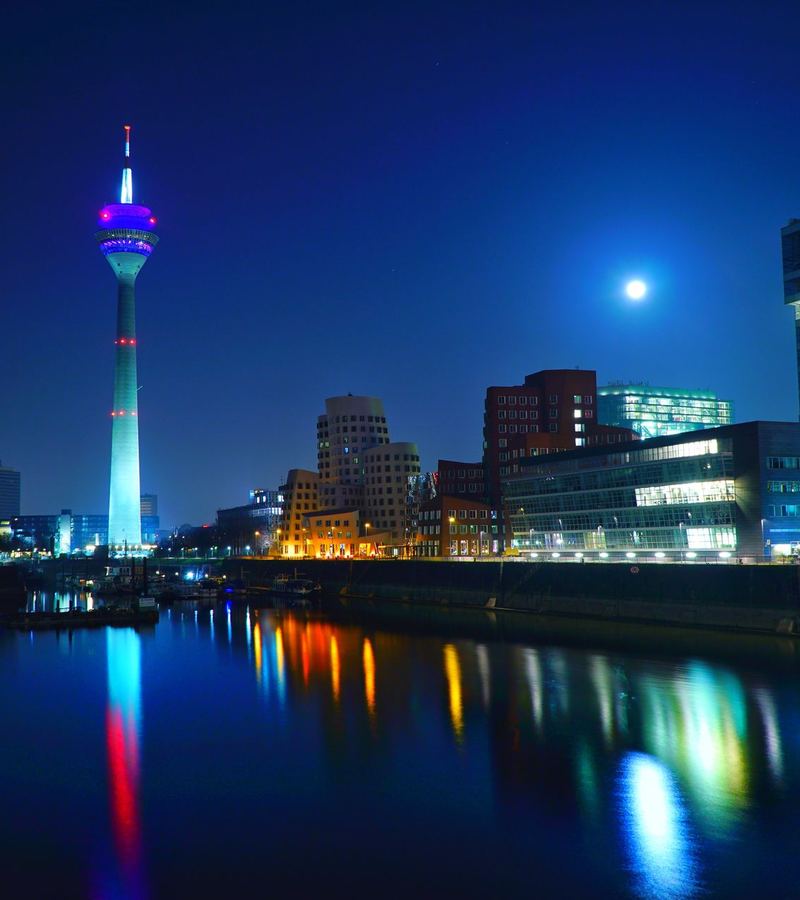 Rheinturm und Skyline von Düsseldorf bei Nacht mit Spiegelung im Rhein