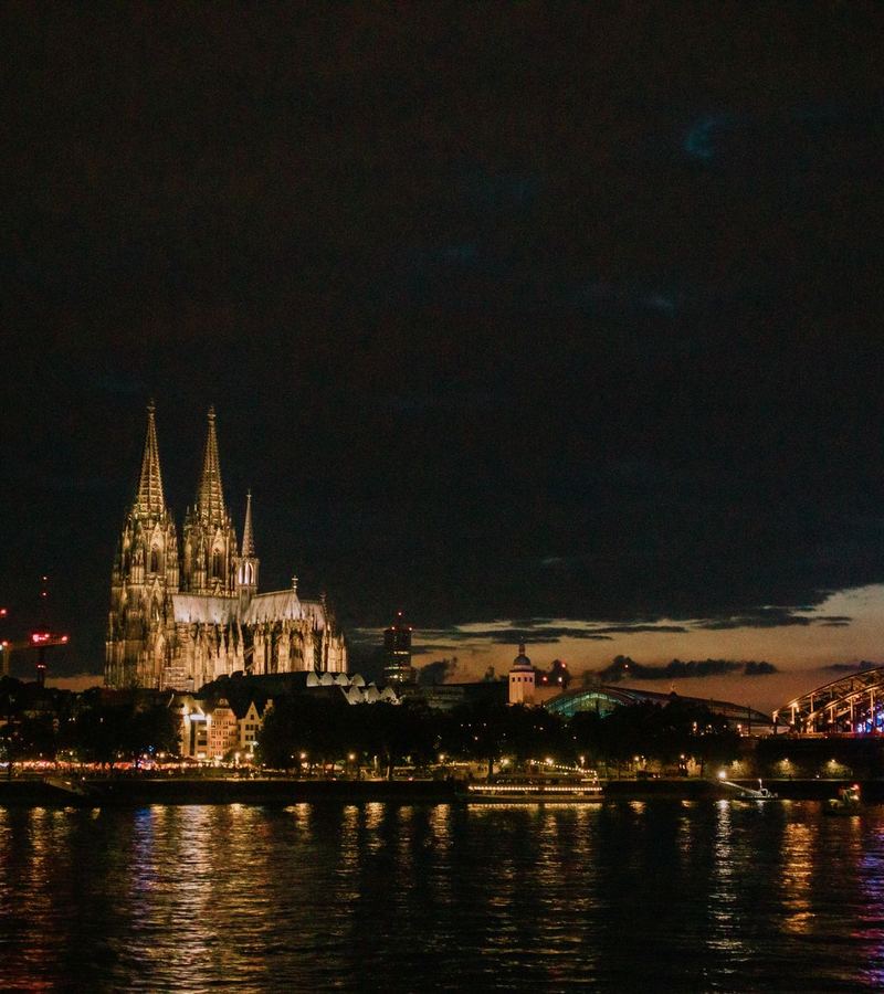Kölner Dom und Hohenzollernbrücke bei Nacht mit Blick auf den Rhein