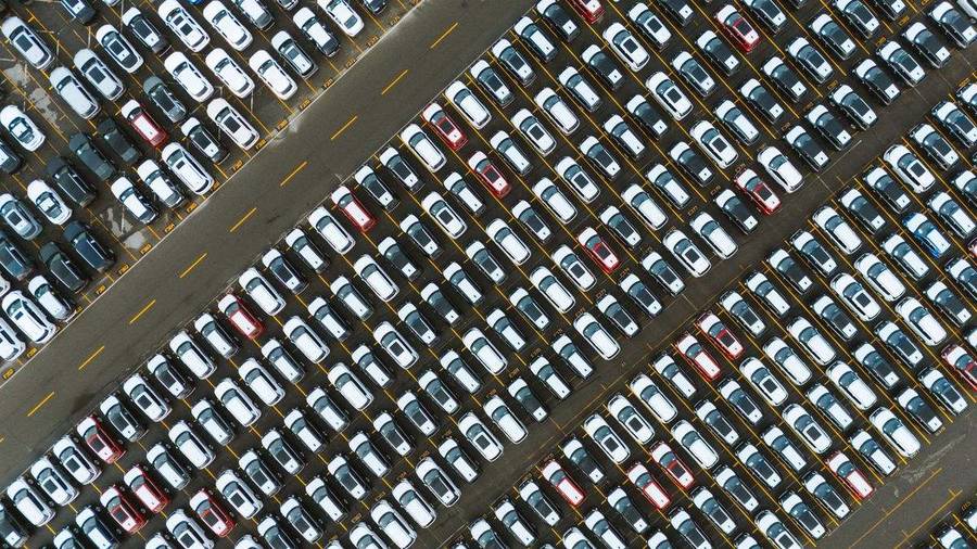 Luftaufnahme eines dicht belegten Parkplatzes mit geordneten Fahrzeugreihen