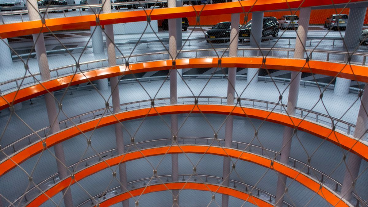 Rundes, modernes Parkhaus mit mehreren Ebenen und zahlreichen Fahrzeugen
